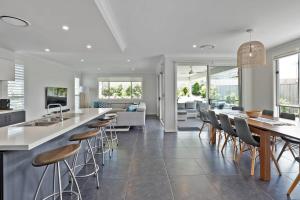 een keuken en een woonkamer met een bar en stoelen bij Spacious And Luxurious Beach Home in Catherine Hill Bay
