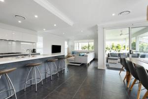 een keuken en een woonkamer met een aanrecht en stoelen bij Spacious And Luxurious Beach Home in Catherine Hill Bay