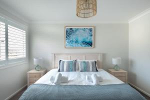 een slaapkamer met een bed met 2 kussens bij Spacious And Luxurious Beach Home in Catherine Hill Bay