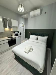 a bedroom with a large bed and a kitchen at The Chapter Hotels - Finsbury Park in London