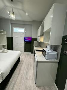 um quarto com uma cama e uma cozinha com um micro-ondas em The Chapter Hotels - Finsbury Park em Londres