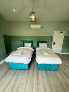 two beds in a room with green walls at The Chapter Hotels - Finsbury Park in London