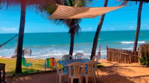 - une table et des chaises sur une plage donnant sur l'océan dans l'établissement Casa da Peroba Sol, à Icapuí