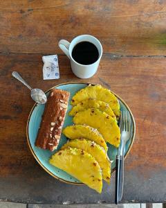 a plate of food with a piece of cake and a cup of coffee at Backpacker Puerto Viejo in Puerto Viejo