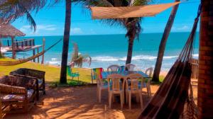 une chambre avec une table et des chaises et la plage dans l'établissement Casa da Peroba Sol, à Icapuí