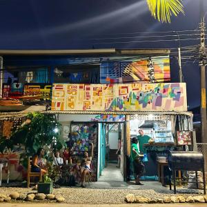 a group of people sitting in front of a store at Backpacker Puerto Viejo in Puerto Viejo