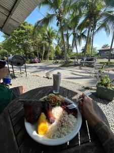 a plate of food with rice and meat on a table at Backpacker Puerto Viejo in Puerto Viejo