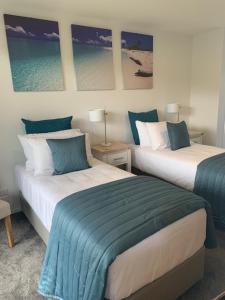 two beds in a room with blue and white at Beachfront Haven in Christchurch