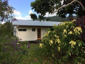 a small white house in a yard with flowers at Mission Beach Rural Escape in Mission Beach