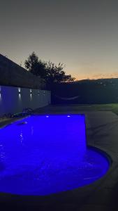 uma piscina azul de água com o pôr do sol em Recanto do sol em Extrema