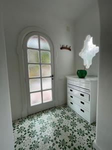 Zimmer mit weißer Kommode und Fenster in der Unterkunft channel house in Ischia