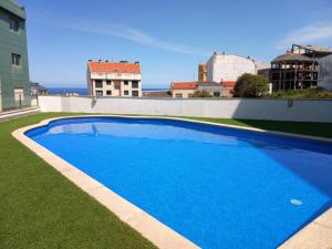 una gran piscina azul en la parte lateral de un edificio en Lanús Malpica de Bergantiños-Costa da Morte, en Malpica de Bergantiños