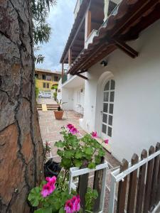 una casa blanca con flores rosas y una valla en channel house, en Isquia