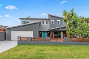 a large house with a fence in front of it at Waterfront Luxury Living & Private Pool Buff Point in Budgewoi