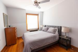 1 dormitorio con 1 cama, ventilador de techo y ventana en Beachside Retreat, en West Haven