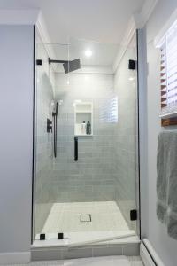 a shower with a glass door in a bathroom at Beachside Retreat in West Haven