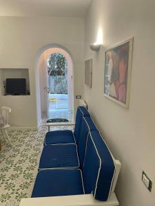 a living room with blue couches and a window at channel house in Ischia