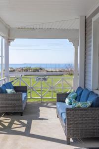 eine Veranda mit zwei Korbsofas auf einem Haus in der Unterkunft Beachside Retreat in West Haven