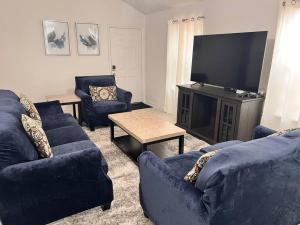 uma sala de estar com sofás azuis e uma televisão de ecrã plano em The Wisteria em Humble