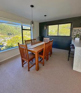 a dining room with a wooden table and chairs at Picton Hilltop Apartment in Picton