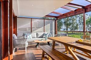 een woonkamer met een tafel en een bank bij Ultimate Lakefront Luxury, Pool Table, Games Room in Berkeley Vale