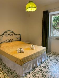 a bedroom with a bed with two shoes on it at channel house in Ischia