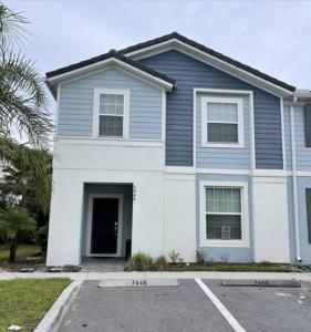 uma casa azul e branca com estacionamento em Theme Paradise House with Pool 7448 em Davenport