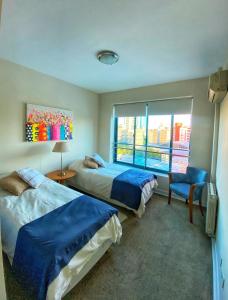 a hotel room with two beds and a window at Edificio Millenium Apartment in Mendoza +26 photos