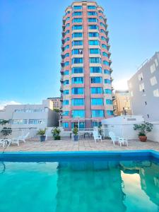 a building with a swimming pool in front of a building at Edificio Millenium Apartment in Mendoza