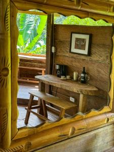 a mirror in a wooden room with a table and a bench at Cabaña Guasale (Toucan) in Guachaca
