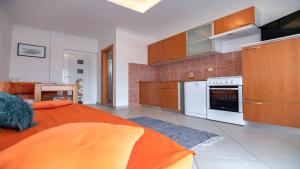 a kitchen with an orange bed in a room at Apartments with parking space Lopar, Rab - 22674 in Lopar
