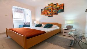 a bedroom with a bed and a painting on the wall at Apartments with parking space Lopar, Rab - 22674 in Lopar