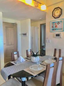 una sala da pranzo con tavolo, sedie e orologio di Twinlakes Tagaytay Merlot ad Alfonso