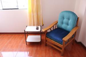 a blue chair and a side table in a room at 2 de Mayo Studio 1 in Tacna