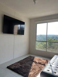 sala de estar con TV de pantalla plana y sofá en Depa Ye, en El Alcanfor