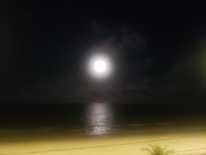 luna llena sobre el océano en la playa en Pousada e Hostel sol e mar en João Pessoa