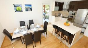 - une cuisine et une salle à manger avec une table et des chaises dans l'établissement Apartments with a swimming pool Stobrec, Split - 22897, à Podstrana