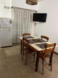 uma cozinha com uma mesa com cadeiras e um frigorífico em Rosario centro em Rosário