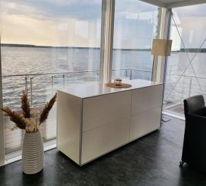 a white cabinet in a room with a view of the water at Ferienhaus Water Grundbelegung 4 Pers in Geierswalde