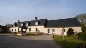 una gran casa blanca con techo negro en Suite & SPA privatif Domaine des Demoiselles, en Hauteville