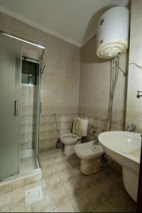 een badkamer met een toilet, een wastafel en een douche bij Abdoun apartment in Amman