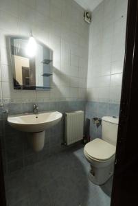 een badkamer met een wastafel, een toilet en een spiegel bij Abdoun apartment in Amman