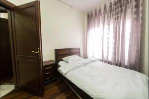 a small bedroom with a bed and a window at Abdoun apartment in Amman