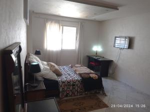 ein kleines Schlafzimmer mit einem Bett und einem Fenster in der Unterkunft Appartement proche de toutes les commodités, RESIDENCE MARWA in Oulad Yakoub