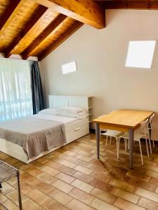 um quarto com uma cama e uma mesa de madeira em Bergamo Easy Airport private parking em Bérgamo