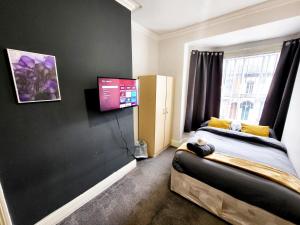 a bedroom with a bed and a flat screen tv at Stay Sleep Rest - De Grey in Hull