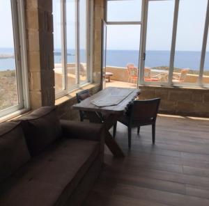 a living room with a couch and a table and windows at Elafonisi Villa above the Beach in Elafonisi