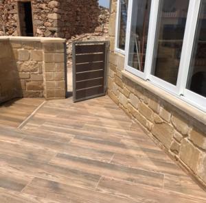 a patio with a brick wall and two windows at Elafonisi Villa above the Beach in Elafonisi