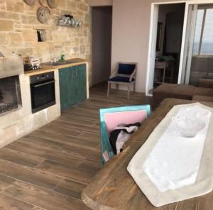 a living room with a table and a kitchen at Elafonisi Villa above the Beach in Elafonisi