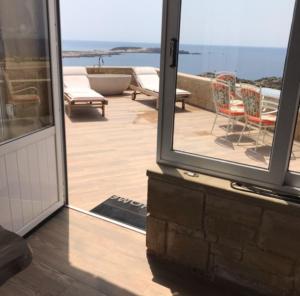 an open sliding glass door with a view of the ocean at Elafonisi Villa above the Beach in Elafonisi